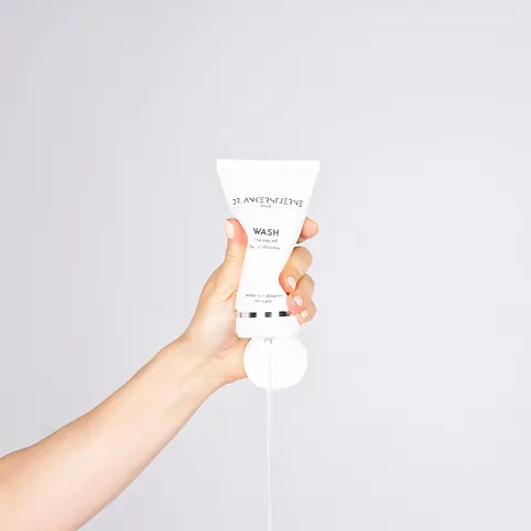 Hånd holder en tube med krem