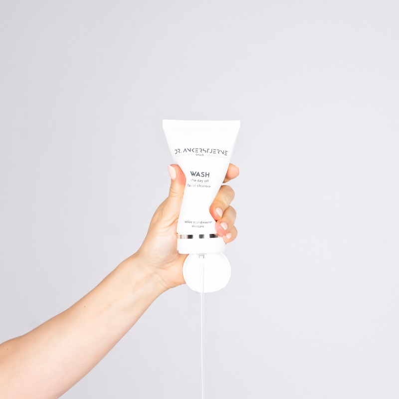 Hånd holder en tube med krem