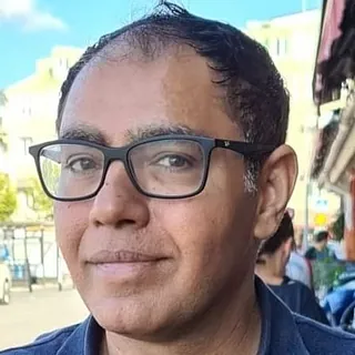 Mann med mørkt hår og svarte briller